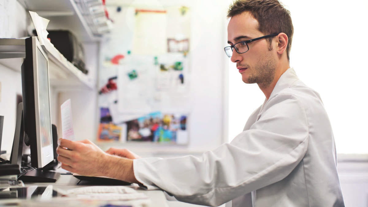 Male scientist working in a laboratory office on a computer